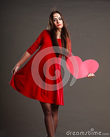 Woman in red dress holds heart sign Stock Photo