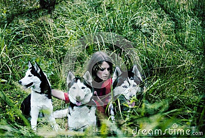 Woman in red dress with tree wolfs, forest, husky dogs mystery portrait Stock Photo