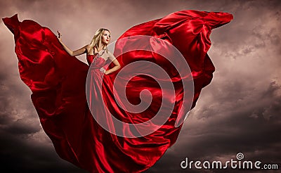 Woman Red Dress Wings, Fashion Model Silk Waving Gown, Flying Fluttering Fabric on Storm Wind Stock Photo