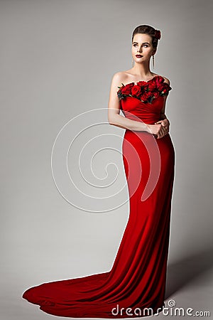 Woman in Red Evening Dress with Flowers Roses, Elegant Fashion Model Beauty Portrait in Long Gown, Studio Portrait Stock Photo