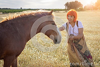 Woman with red hair near of a horse Stock Photo