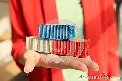 Woman in red jacket holds multicolored containers in hand Stock Photo