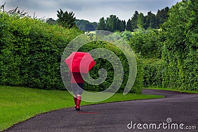 Woman with red umbrella on an overcast day. Stock Photo