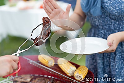 Woman refusing frazzled sausage Stock Photo