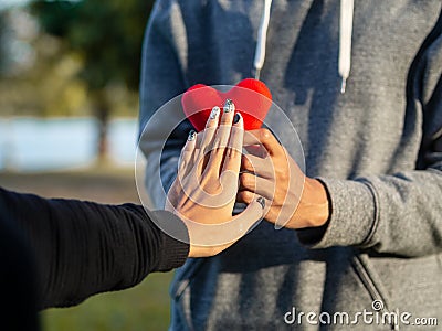 Woman refusing red heart form the man. Broken heart, Love, Valentine`sDay Concept Stock Photo