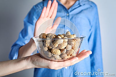 Woman refusing to eat peanuts. Food allergy concept Stock Photo