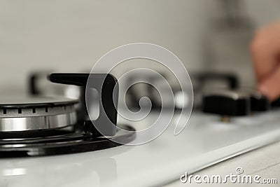 Woman regulating cooking mode on gas stove panel Stock Photo