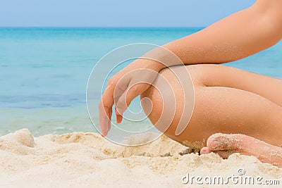 Woman in relaxation on nice beach with sand on hand leg and body Stock Photo