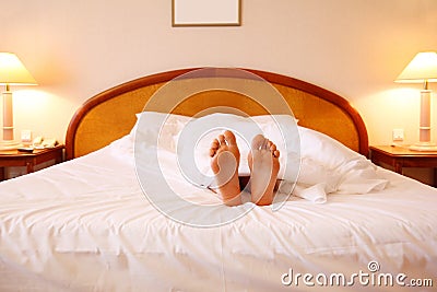 Woman relaxing on bed with white sheets Stock Photo