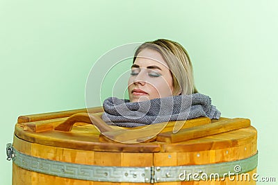 Woman in cedar spa barrel body rejuvenation and relax sauna Stock Photo