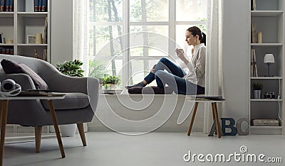 Woman relaxing at home and having coffee Stock Photo