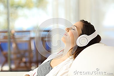 Woman relaxing listening to music on a couch Stock Photo