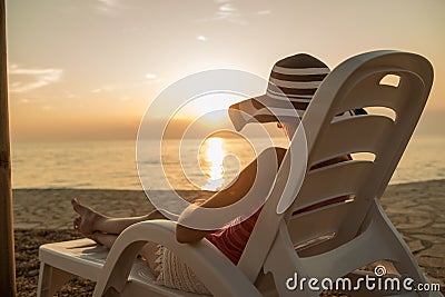 Woman relaxing on a recliner at the beach Stock Photo