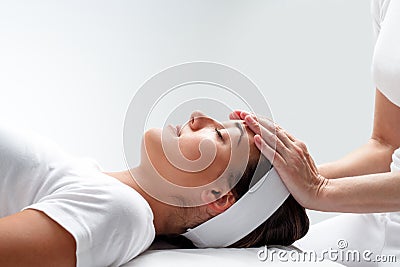 Woman relaxing at reiki session. Stock Photo