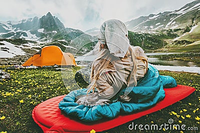 Woman relaxing in sleeping bag on red mat camping Stock Photo