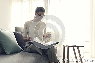 Woman relaxing on the sofa and watching pictures in the photo album Stock Photo