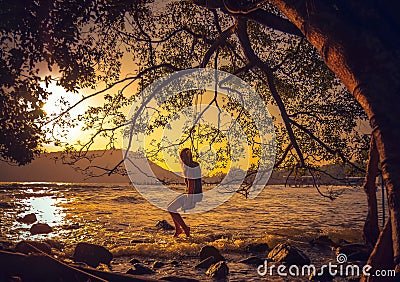 Woman relaxing on a swing on the beach Stock Photo