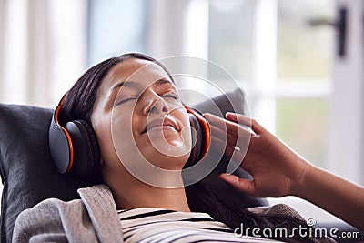 Woman Relaxing Taking A Break Lying On Sofa Listening To Music On Wireless Headphones Stock Photo