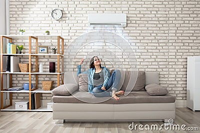 Woman Relaxing Under The Air Conditioner Stock Photo