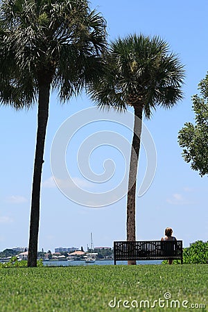 Woman Relaxing Watching the Sailboats Stock Photo