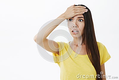 Woman remembered important thing she forgot do feeling anxious and concerned punching forehead with palm staring left Stock Photo
