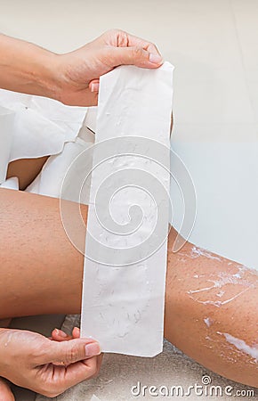 Woman removing hair from her legs and show fabric Stock Photo