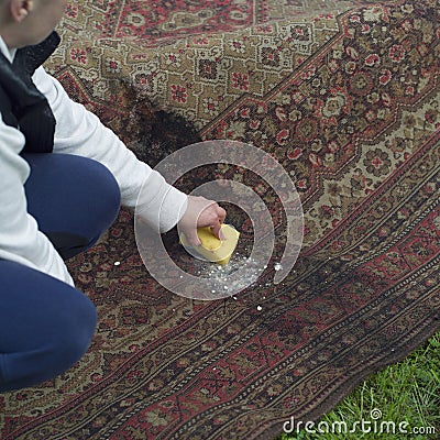 Woman removing mold from a carpet Stock Photo