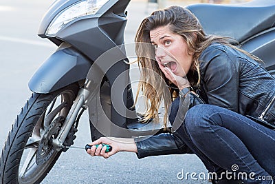 Woman repairs scooter Stock Photo