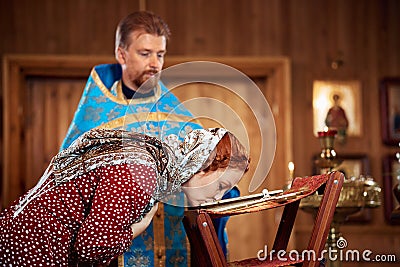 a woman repents of her sins, confessions with a priest in an Orthodox church Stock Photo