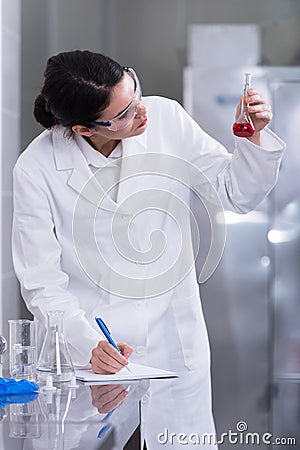 Woman researcher doing a lab test and making notes Stock Photo