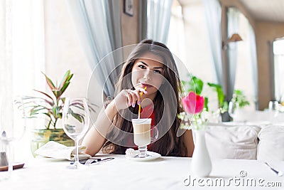 A woman in a restaurant is drinking cocktail Stock Photo