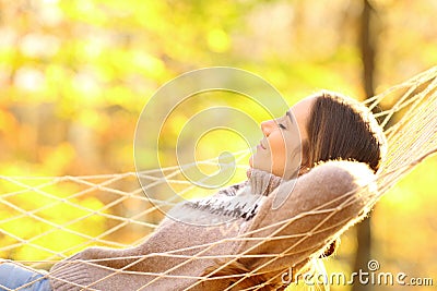 Woman resting lying on hammock in autumnal forest Stock Photo