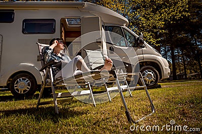 Woman resting near motorhomes in nature. Family vacation travel, holiday trip in motorhome RV, Caravan car Vacation. Stock Photo