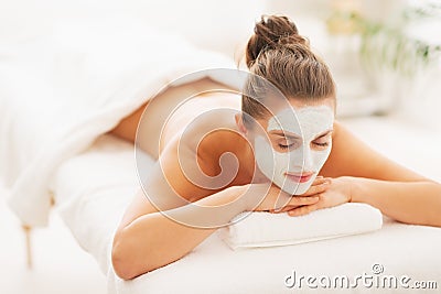 Woman with revitalising mask on face laying on massage table Stock Photo