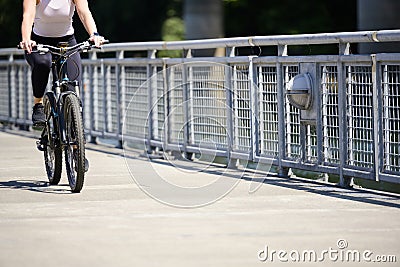 Woman rides a bicycle along a path along a river Editorial Stock Photo