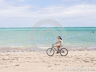 Woman riding bike at the beach Editorial Stock Photo