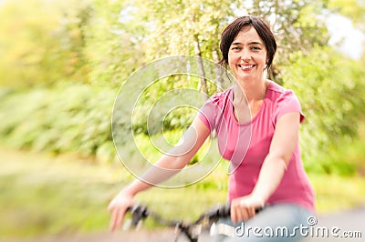 Woman riding bike on forest meadow. Stock Photo