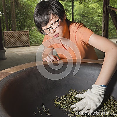 Woman roasting tea leaves Stock Photo