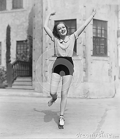 Woman roller-skating on a side walk Stock Photo