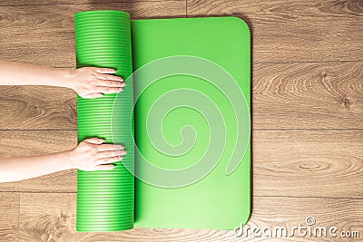Woman rolling her Yoga mat after a training - top view. Concept healthy lifestyle, sport Stock Photo