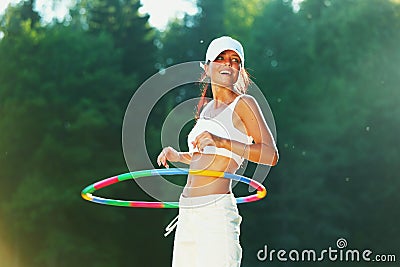 Woman rotates hula hoop Stock Photo