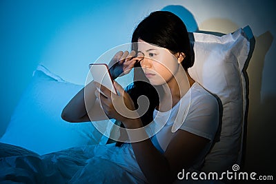 Woman rubbing eyes with using smartphone Stock Photo