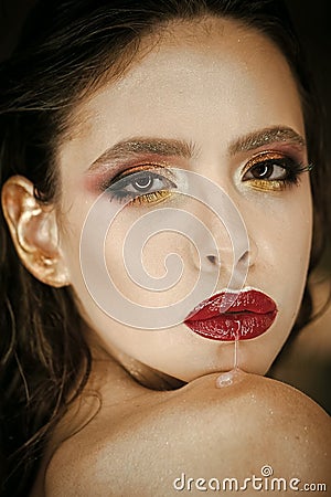 Woman run saliva from mouth with red lips, makeup. Woman with fresh skin face, skincare. Beauty model with glamour look Stock Photo