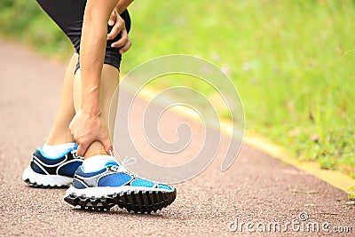 Woman runner holder her twisted ankle Stock Photo