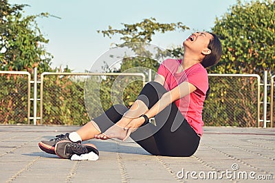 Woman runner hurting holding painful sprained ankle in pain Stock Photo