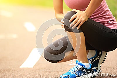 Woman runner injured knee Stock Photo