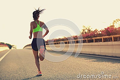 Woman runner running on city bridge road Stock Photo