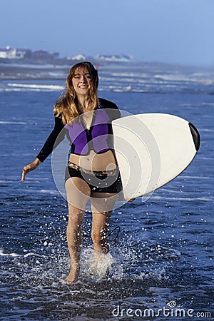 Woman runnibg with surfboard Stock Photo