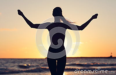 Woman running alone at beautiful dusk on the beach Stock Photo