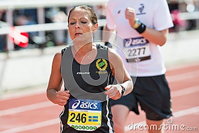 Woman running the final stretch at Stockholm Stadion in ASICS St Editorial Stock Photo